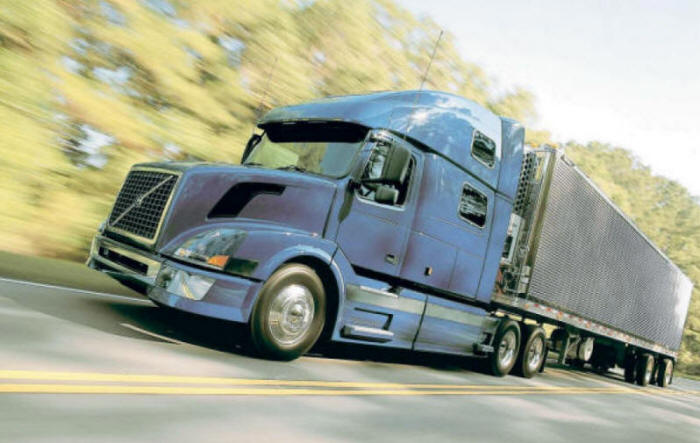 Blue Volvo Truck with "refer" refrigerated trailer on highway