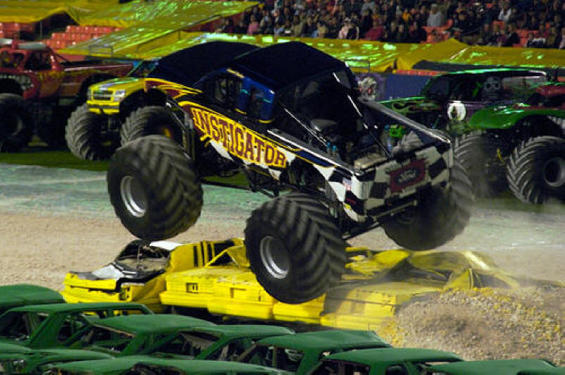 Instigator Monster Truck taking off over a line of cars